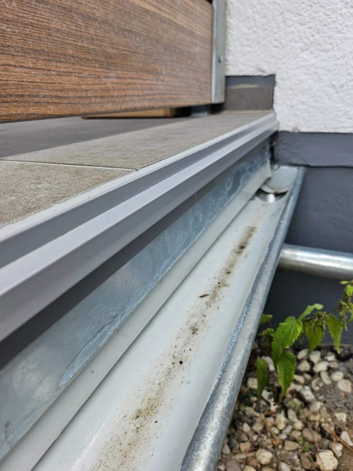 Neue Dachrinne mit Randprofil an der Balkonkante unter der Holzverkleidung