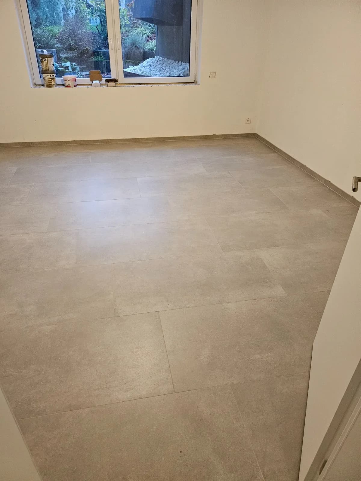 Wohnraum mit hellem großformatigen Fliesenboden am Fenster