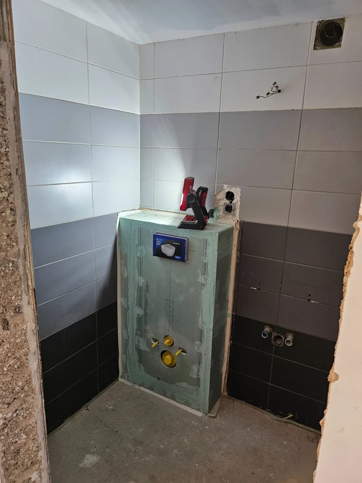 Badezimmer im Rückbau mit freigelegtem Mauerwerk und Vorwandelement