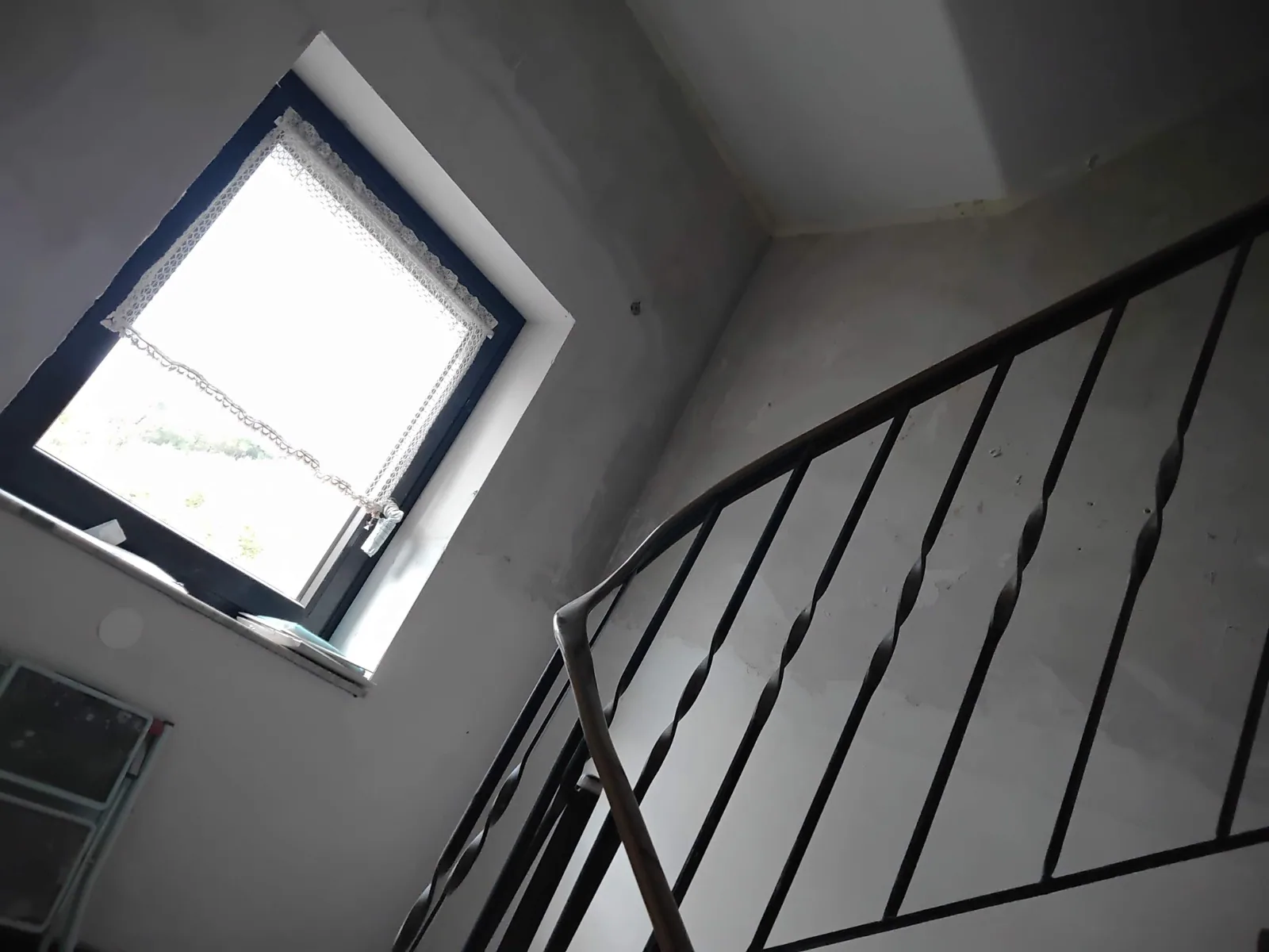 Treppenhaus mit Geländer und Fenster während der Sanierungsarbeiten