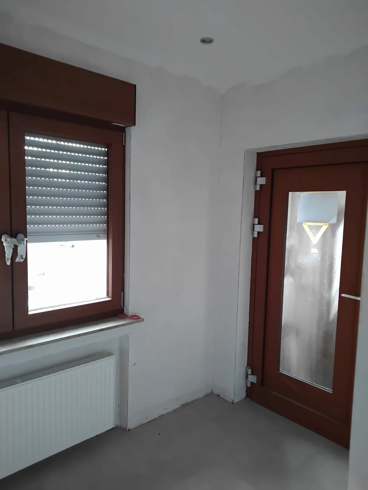 Helle Wandflächen im Eingangsbereich neben Tür und Fenster