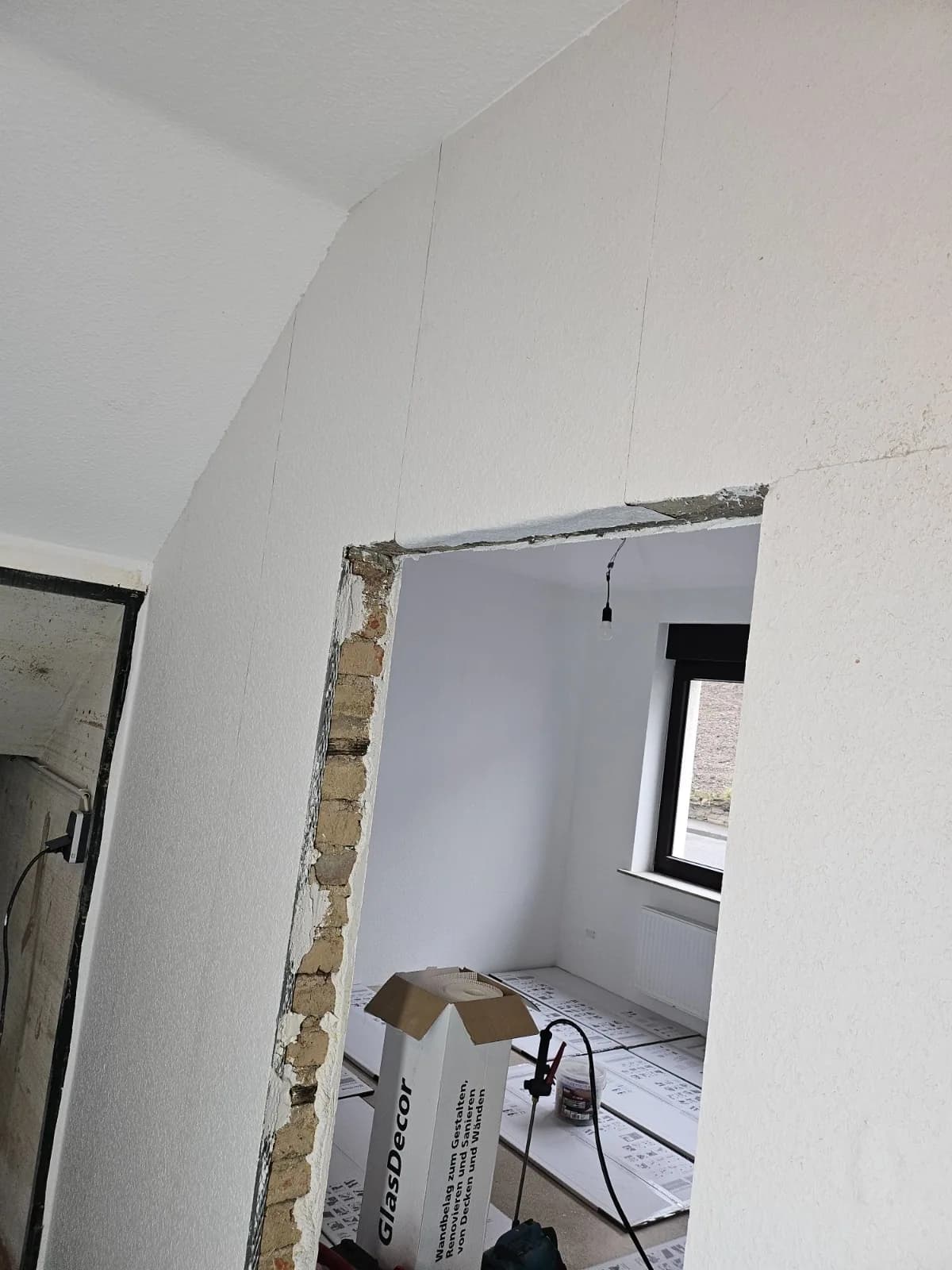 Tapezierte Wand über einem noch offenen Türdurchgang